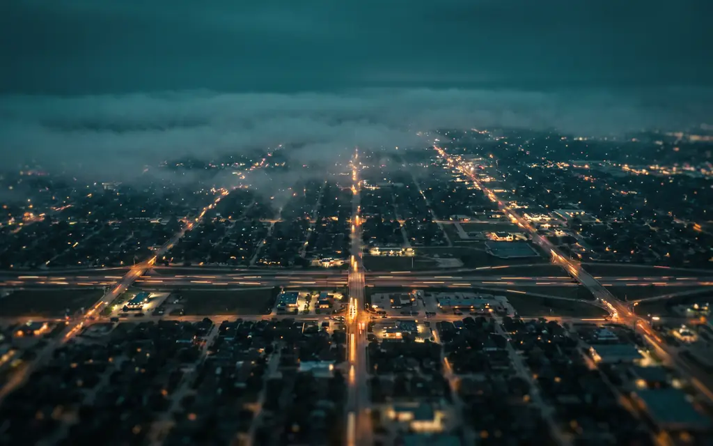 Aerial night view of a Texas city grid with glowing highways